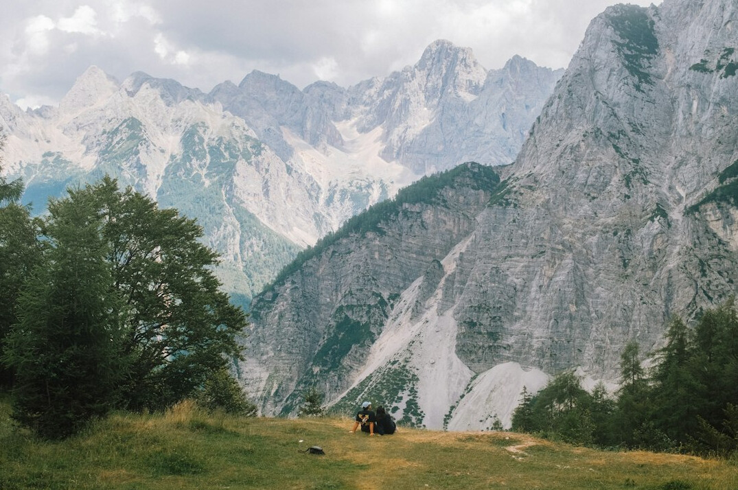 Health instructor guiding a small group outdoor stretching class in the Slovenian mountains